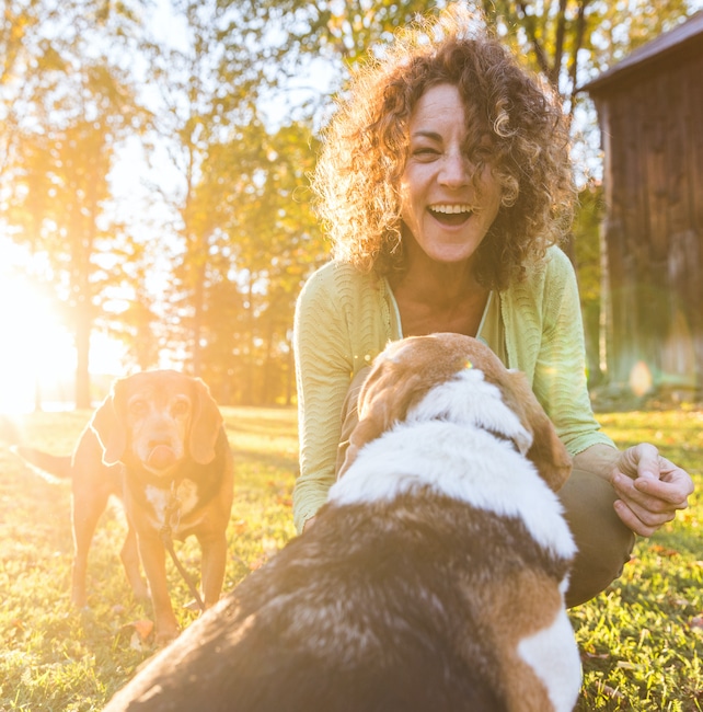 Adult,Woman,Playing,With,Her,Dogs,At,Park,Or,In